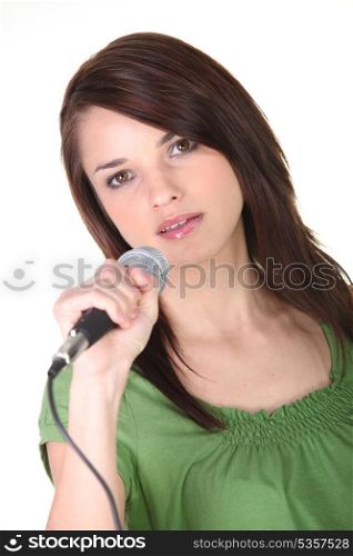 Girl singing into microphone on white background