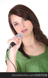 Girl singing into microphone on white background