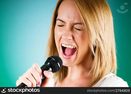 Girl singing with microphone against gradient background