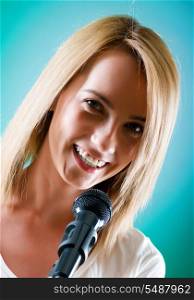 Girl singing with microphone against gradient background