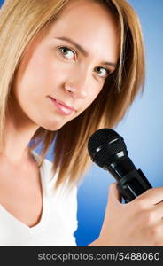 Girl singing with microphone against gradient background