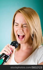 Girl singing with microphone against gradient background