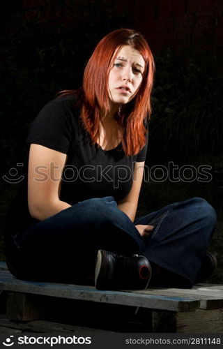 Girl siting on wood, flash lighting, redhead. Lit with two offcamera flashes.