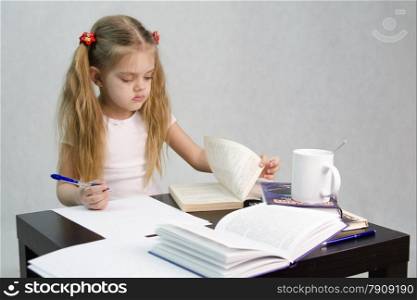 girl sits at a table and flips through the book and writes out the information you need. Next are still books, sheets of paper, a pen, a glass of tea. The image of a student, a pupil, a teacher and literary critic