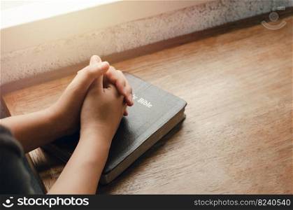 girl sitting and praying for blessings from god With the Bible folded hands in biblical, spiritual and religious prayer, communicate, talk to God. love and forgiveness