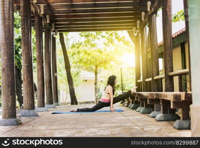 Girl sitting doing split meditation yoga outdoors, woman doing side split yoga outdoors, young woman doing side split yoga