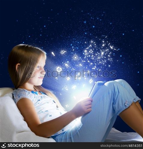 Girl sitting in bed and playing with tablet pc