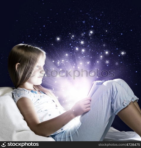 Girl sitting in bed and playing with tablet pc