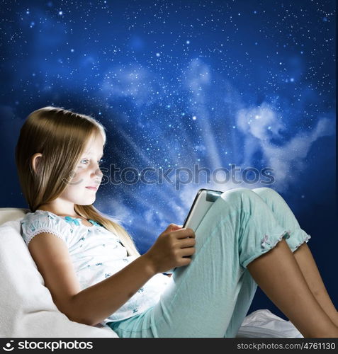 Girl sitting in bed and playing with tablet pc