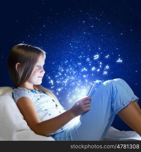 Girl sitting in bed and playing with tablet pc