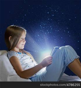 Girl sitting in bed and playing with tablet pc
