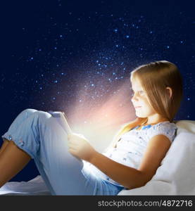 Girl sitting in bed and playing with tablet pc