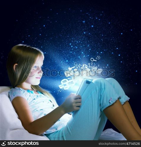 Girl sitting in bed and using tablet pc