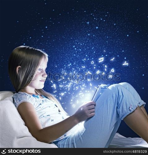 Girl sitting in bed and using tablet pc