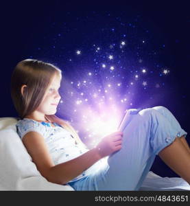 Girl sitting in bed and using tablet pc