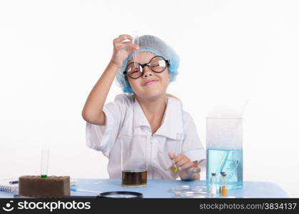 Girl sitting in chemistry class and makes the simplest experiments