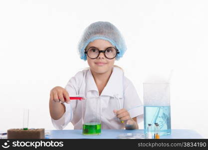 Girl sitting in chemistry class and makes the simplest experiments