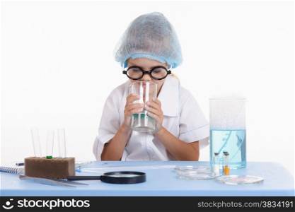 Girl sitting in chemistry class and makes the simplest experiments