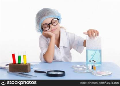 Girl sitting in chemistry class and makes the simplest experiments