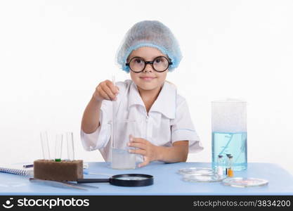 Girl sitting in chemistry class and makes the simplest experiments