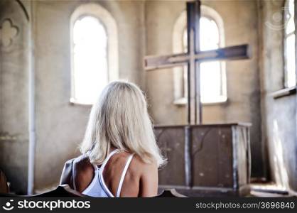 Girl sitting in front of the church cross.