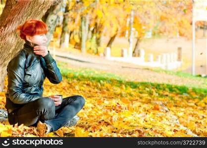 girl sitting in maple autumn sunny day