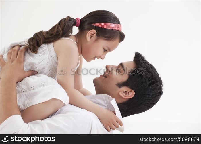 Girl sitting on father&rsquo;s stomach