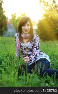 Girl sitting on green grass in spring