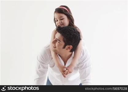 Girl sitting on her father&rsquo;s back