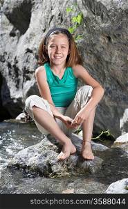 Girl Sitting on Rock in Brook