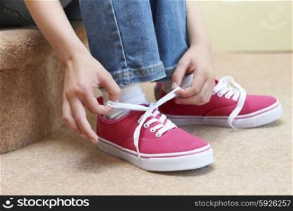 Girl Sitting On Stairs And Tying Shoelaces