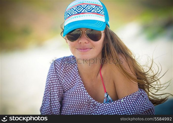 Girl Sitting on the Beach Wearing Sunglasses