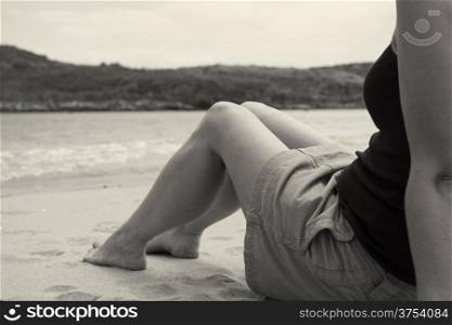 Girl sitting on the edge of the beach on a gloomy day
