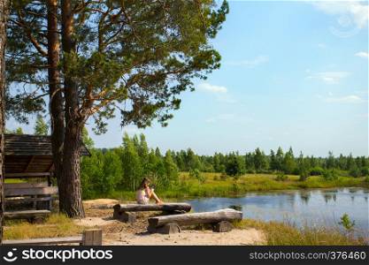 girl sitting on the shore of the lake and reading a book, Ukrainian landscape