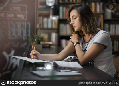 girl sitting table with notebooks writing