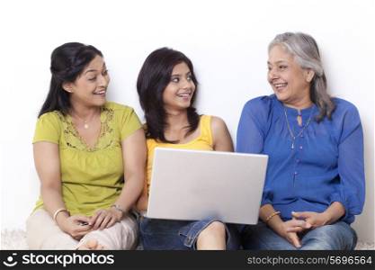 Girl sitting with her mother and grandmother shopping online