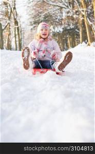 Girl Sledging Through Snowy Woodland