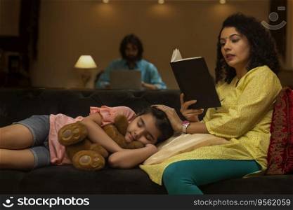 Girl sleeping on sofa while her mother reading book and father using laptop