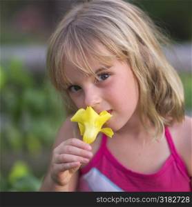 Girl smelling a yellow flower