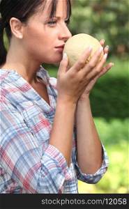 Girl smelling melon