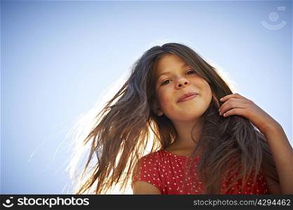 Girl smiling against blue sky