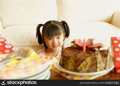 Girl smiling and looking at a cake