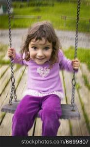 Girl Smiling On Swing