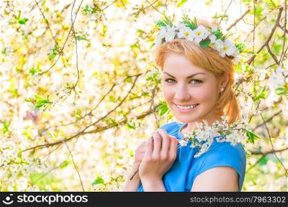 girl smiling on the background of blossoming cherry in the park