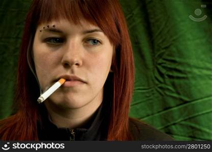 Girl smoking cigarette and bored, green background, looking away