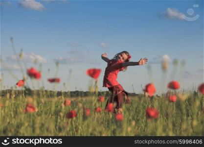 Girl stand with arms outstretched in the poppies field and enjoy the nature. Girl in poppies