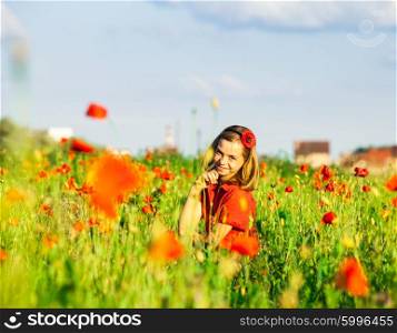Girl stand with arms outstretched in the poppies field and enjoy the nature. Girl in poppies