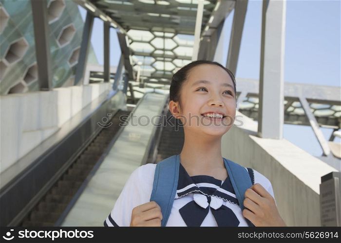 Girl standing and smiling next to the escalator near the subway station