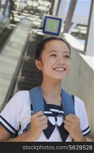 Girl standing and smiling next to the escalator near the subway station