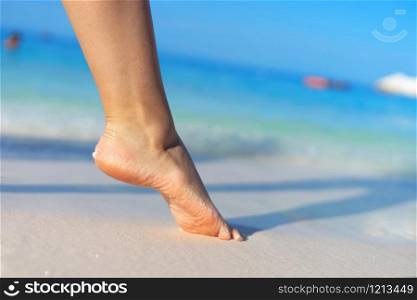 Girl standing barefoot on the sand beach female feel walking in summer vacation sunny day by the sea or ocean